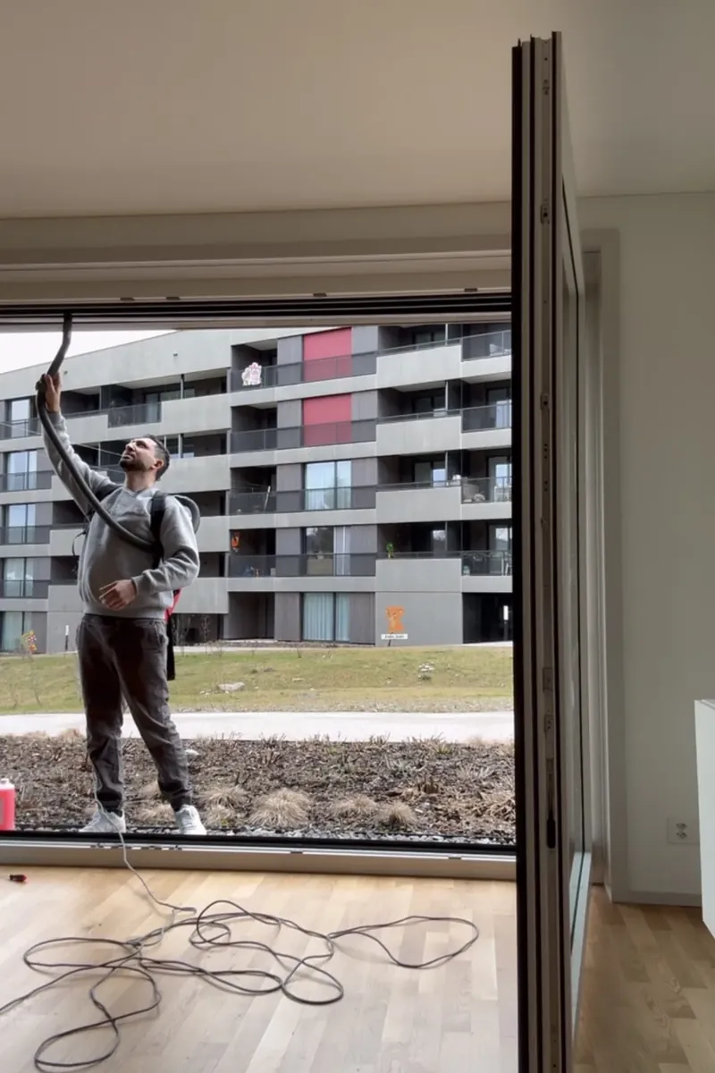 Arnel Zimmermann working around a large window frame